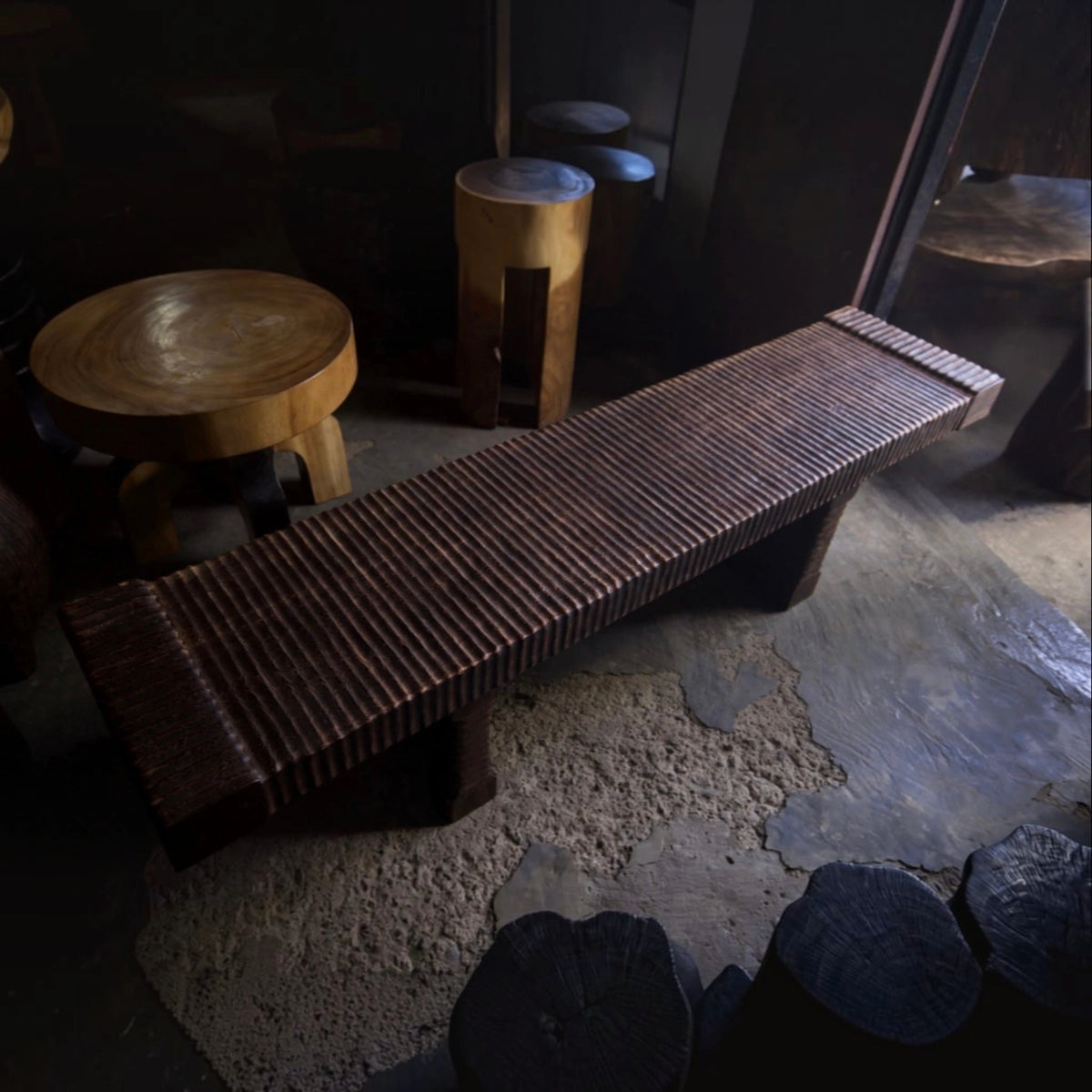The hand-carved solid mango wood bench presented within Senja’s signature modern organic luxury branding setting surrounded by curated sculptural art furniture.