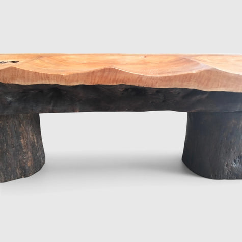 Architectural profile of Senja modern organic bench showcasing dark textured natural wood bark crust and heavy solid timber leg columns.