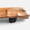 Detailed side view of Senja modern organic bench showcasing the carved concave seating wave, a natural wood checking crack, and a dark solid leg base.