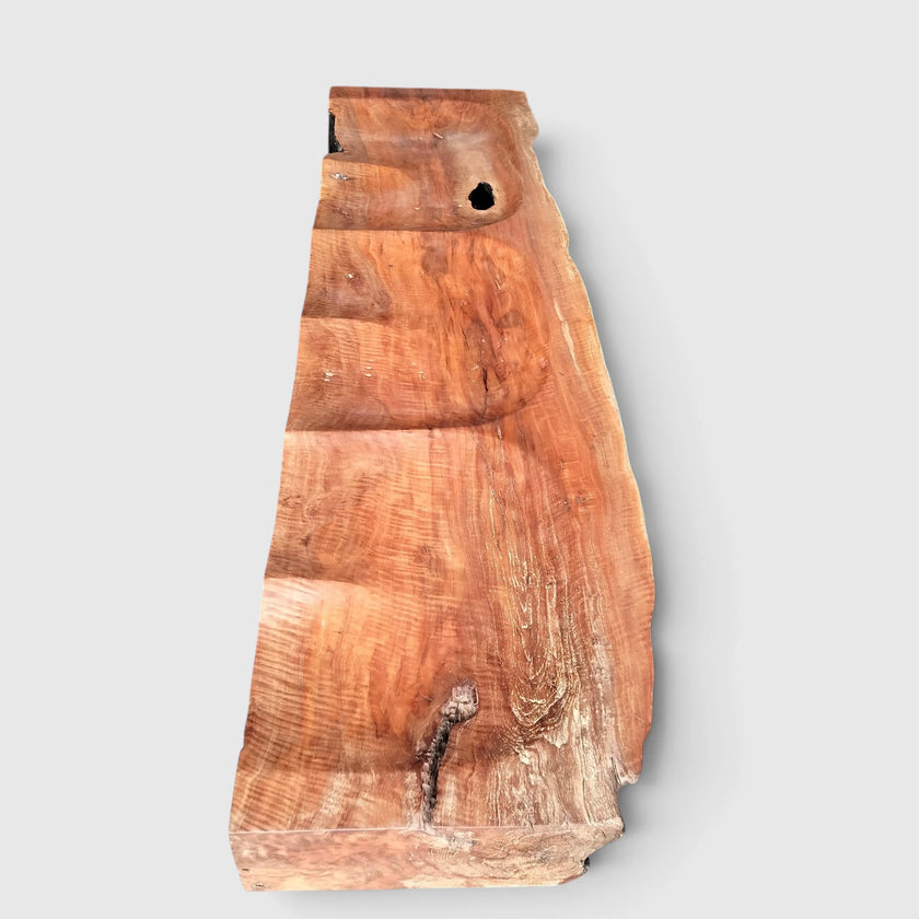 Top-down view of Senja modern organic bench showcasing the natural live-edge slab silhouette and rich swirling grain of the carved lychee wood.