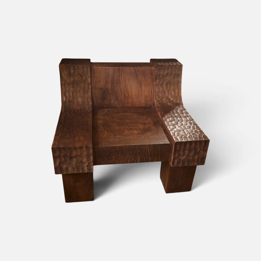 Front view of the modern organic brutalist sculptural lounge chair No.99 by Senja Living, showcasing the grand architectural scale of the statement piece and its beautiful lightly charred multi-tonal warm chestnut color with amber undertones.