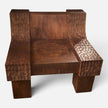 Close-up macro front view of the modern organic brutalist lounge chair No.99 by Senja Living, illustrating the pure scale of its solid mango wood architecture and fire-torched charred multi-tonal warm chestnut hues.