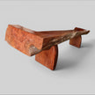 An angled back view of the Sculptural Live Edge Bench by Senja Living, highlighting the full length of the beautifully polished outer surfaces and the wonderfully designed wedge blocks.