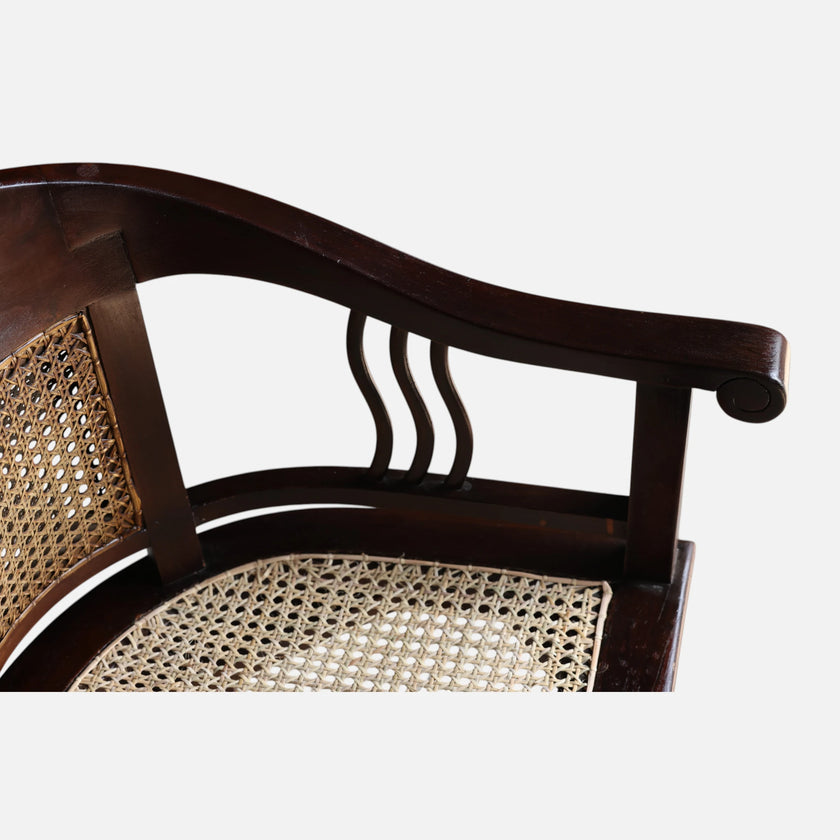 Close-up of the sculpted teak armrest and undulating wood splats on the Colonial Art Deco Teak Tub Back Armchair by Senja Living.