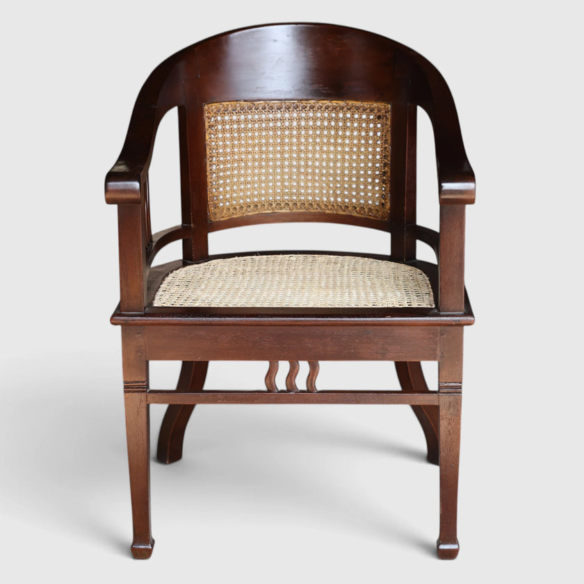Front detail view of the Colonial Art Deco Teak Tub Back Armchair by Senja Living, highlighting the hand-woven cane seat and curved elegant teak frame.