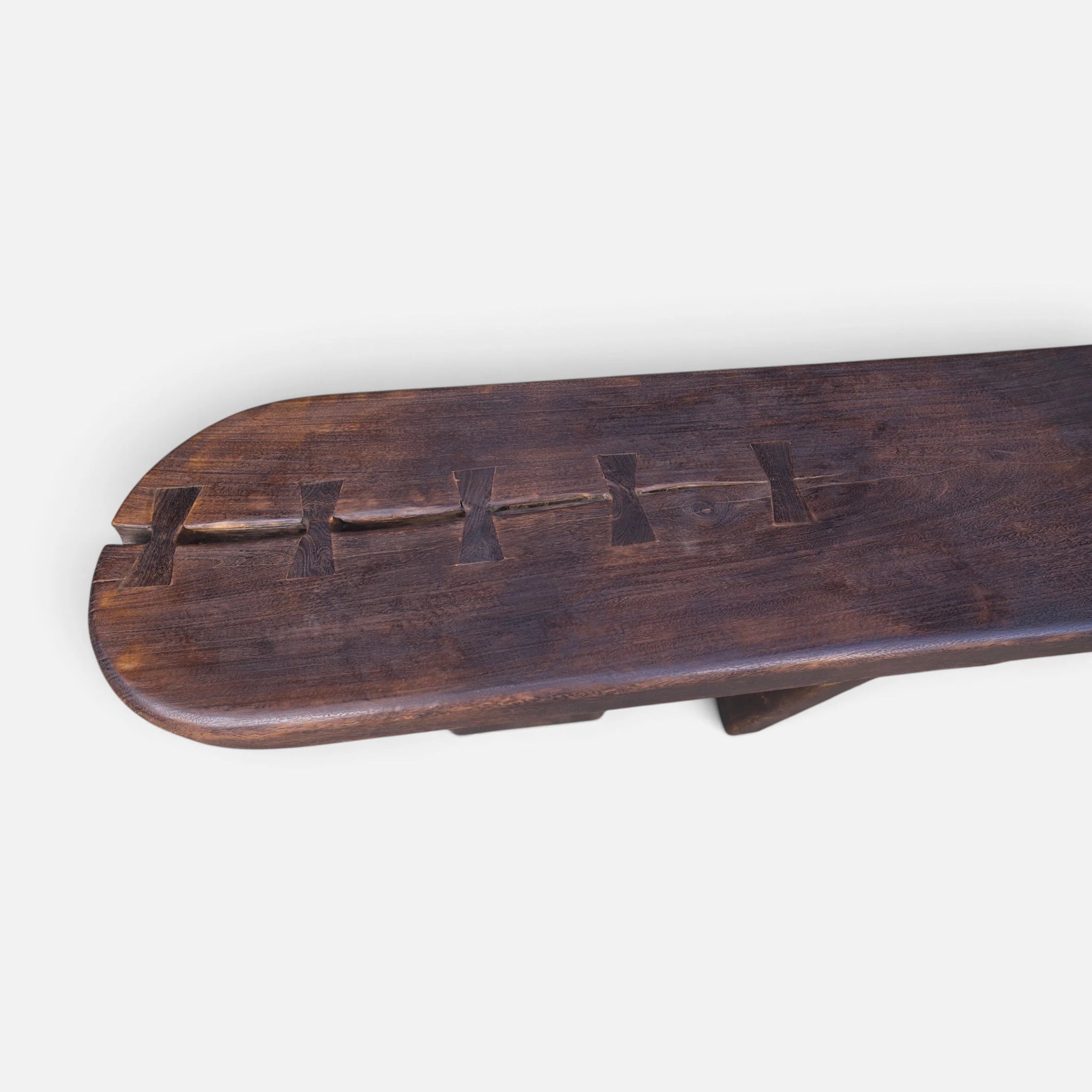 Close-up overhead studio shot of the solid mango wood console table highlighting the prominent hand-keyed butterfly joints and natural wood grain splits.