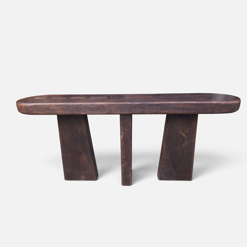 Full straight front-facing studio shot of the solid mango wood console table showing its three monumental block legs and fire-torched finish.