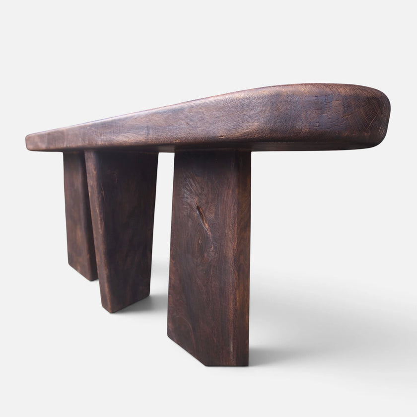 Low-angle studio shot of the solid mango wood console table highlighting its thick block legs and monumental architectural silhouette.