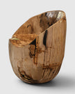 Hero view of the Senja petrified wood warm beige statement dining chair and accent chair showing the contrast between its warm refined organic bark exterior with remarkable dark brown and black vertical fossil streaks and highly polished scooped seat.