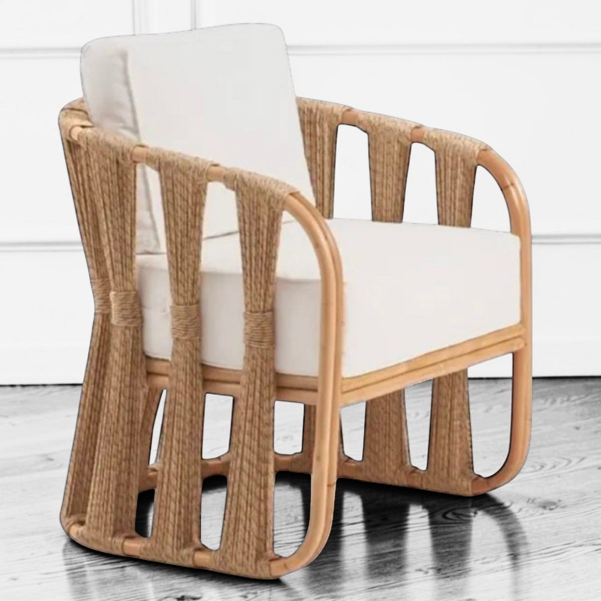 High-contrast lifestyle vignette of the Senja Ropes Attached Accent Chair showcasing the architectural shadow lines of the double-pole rattan frame in a strings attached lounge chair style.
